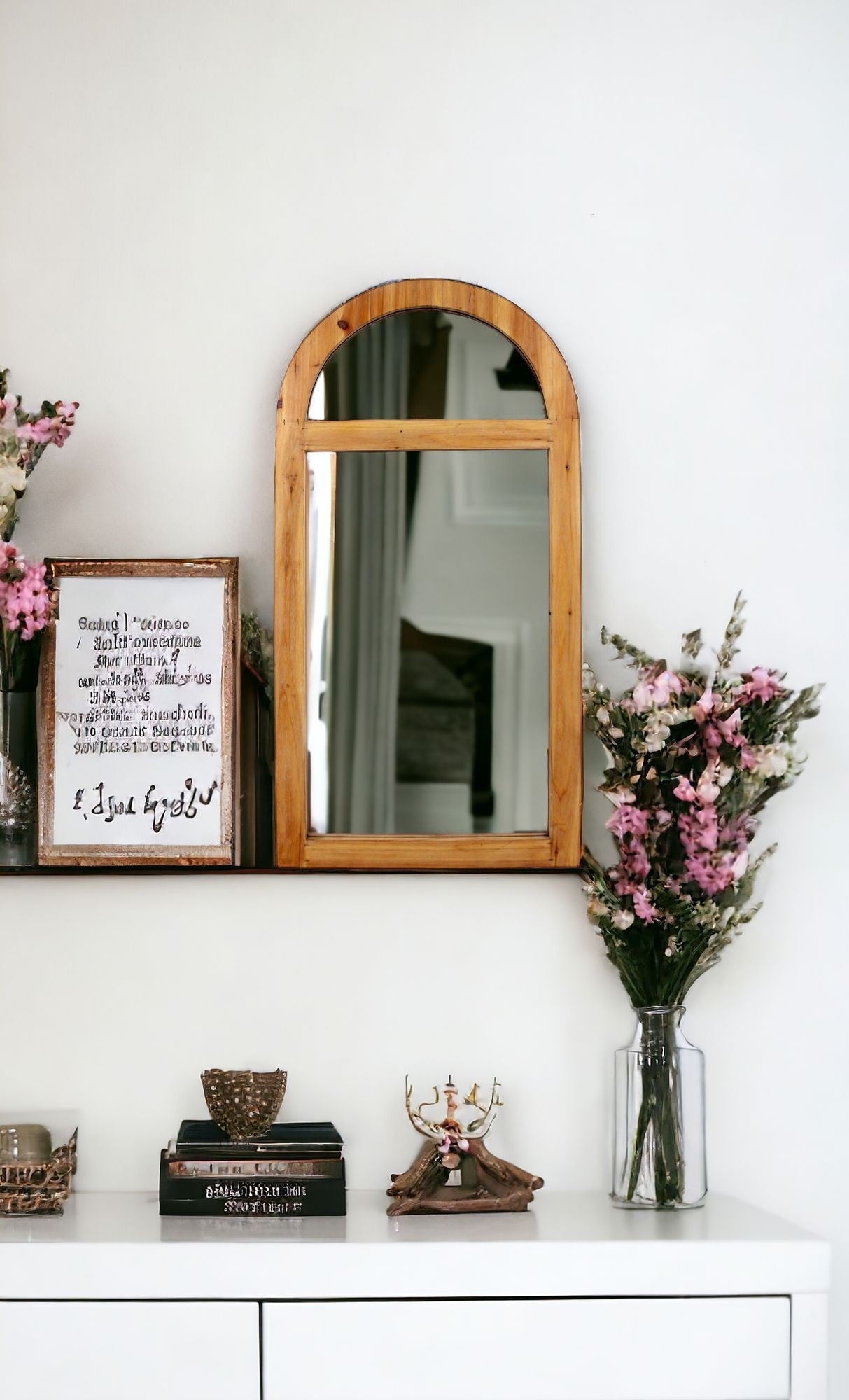 Wood frame arch accent mirror with half moon mirror on top and rectangular mirror below separated by wood piece sitting on a shelf