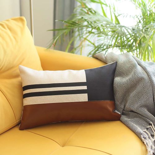 Polyester and mix faux leather brown and black geometric lumbar pillow set on a couch