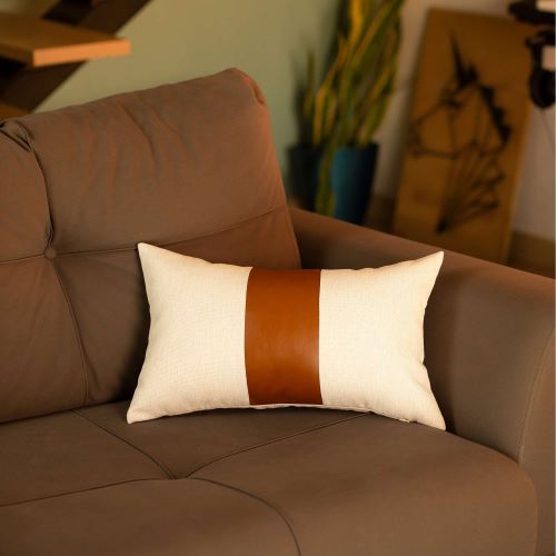 Polyester white lumbar pillow with brown faux leather midsection set on couch