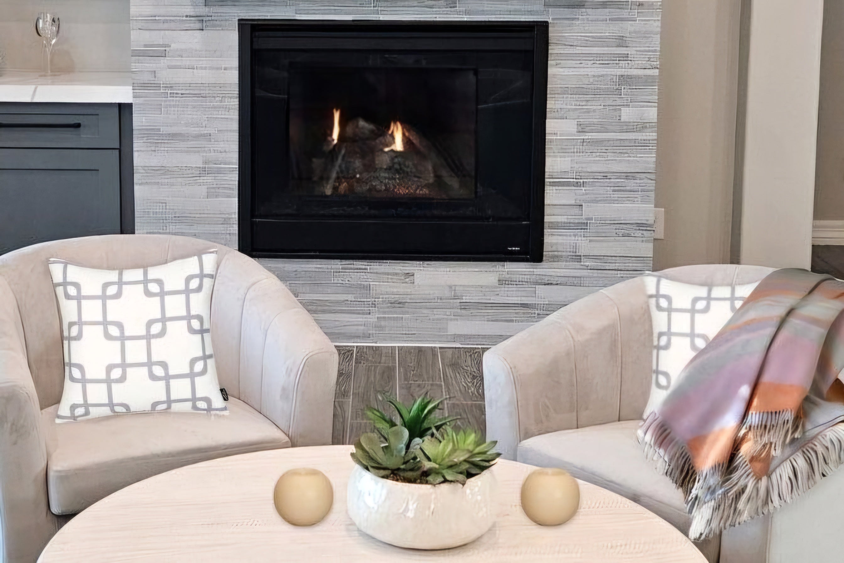 living room with two chairs and throw pillows, round flameless candles on circular coffee table